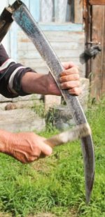 man-sharpening-scythe-mowing-village-95632035.jpg